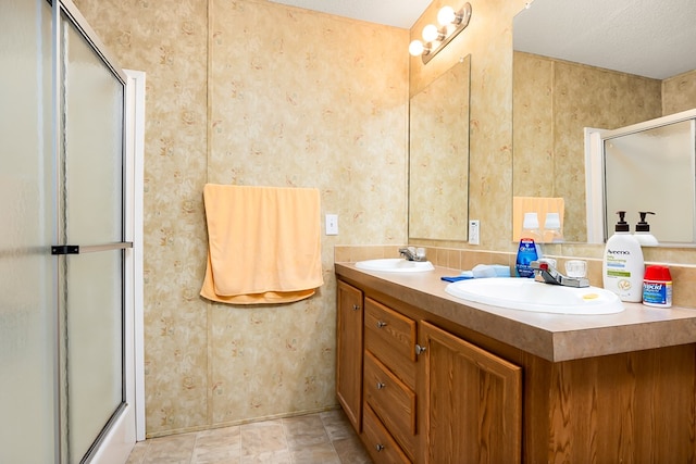 bathroom featuring walk in shower, vanity, and a textured ceiling