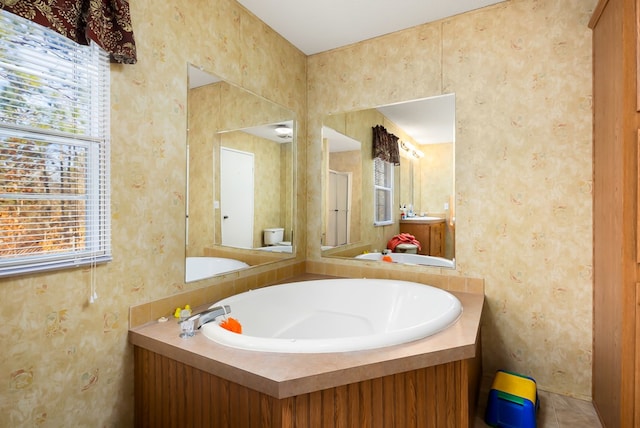 bathroom with vanity and a washtub