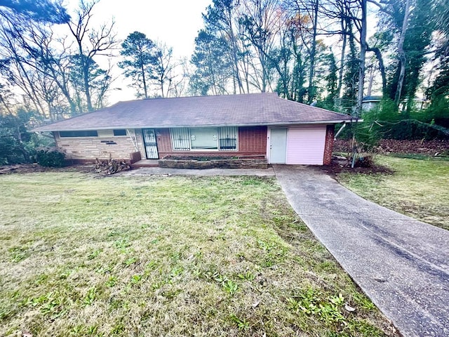 ranch-style house with driveway, brick siding, and a front yard