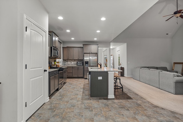 7546 Mockernut Way, Midland, GA 31820 - kitchen with stainless steel appliances, open floor plan, a breakfast bar, ceiling fan, and backsplash