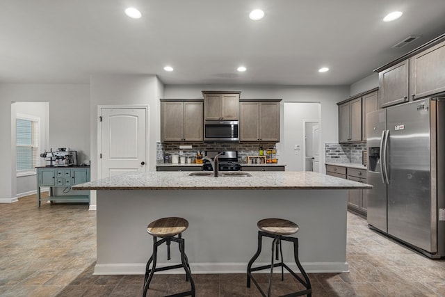7546 Mockernut Way, Midland, GA 31820 - kitchen with stainless steel appliances, a sink, light stone counters, decorative backsplash, and recessed lighting