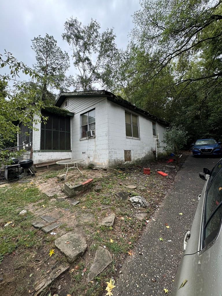 view of property exterior with a sunroom and cooling unit