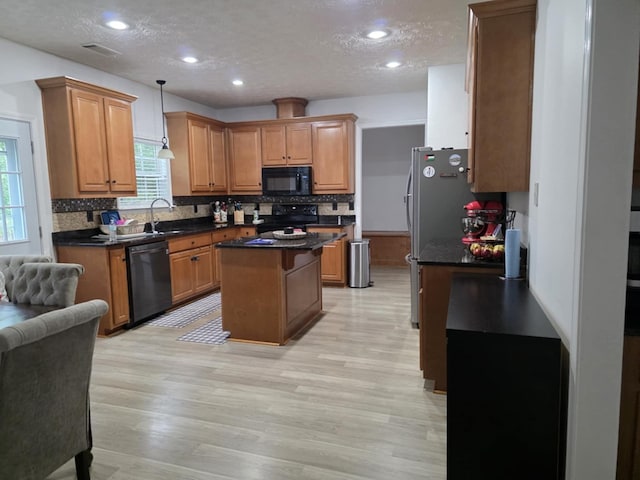 10315 Whisper Glen Ct, Midland, GA 31820 - kitchen with black appliances, a kitchen island, a textured ceiling, dark countertops, and decorative backsplash