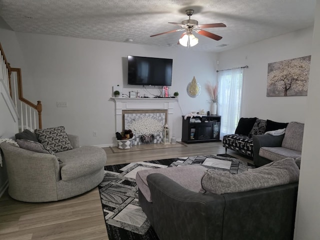 10315 Whisper Glen Ct, Midland, GA 31820 - living area featuring stairway, a fireplace, wood finished floors, ceiling fan, and a textured ceiling