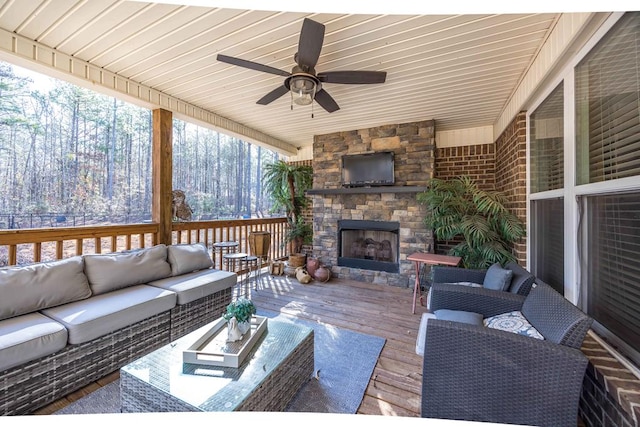 living room featuring an outdoor stone fireplace, a ceiling fan, wood ceiling, and hardwood / wood-style floors
