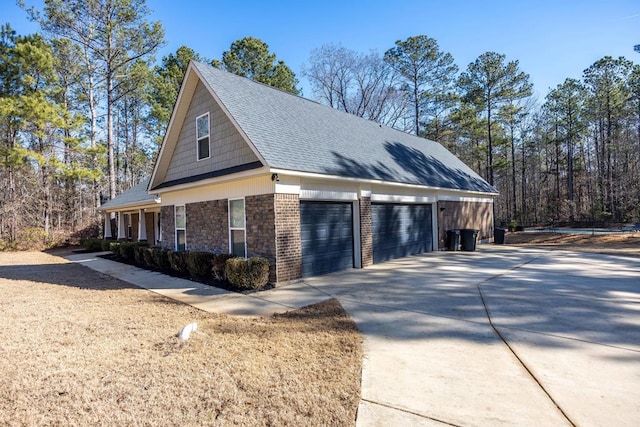 view of property exterior with a detached garage, roof with shingles, and brick siding