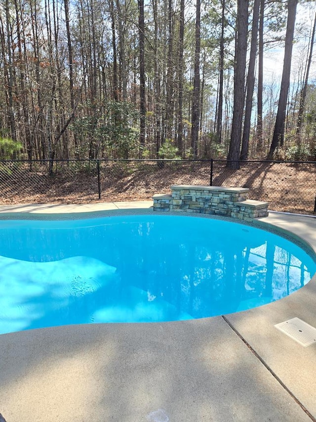 outdoor pool featuring fence