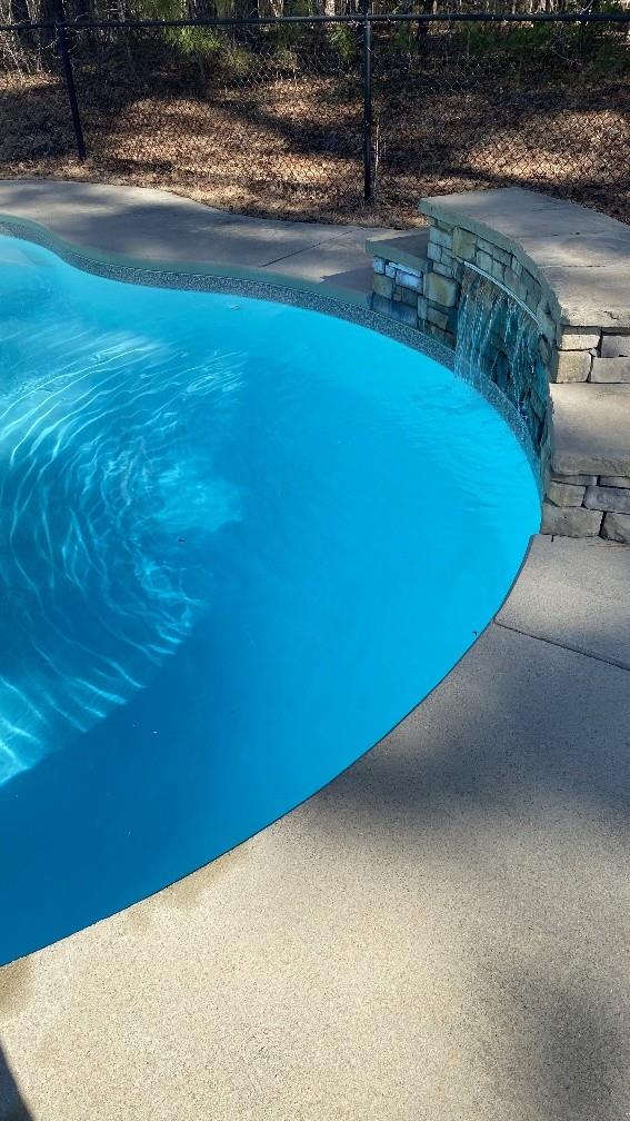 outdoor pool featuring fence