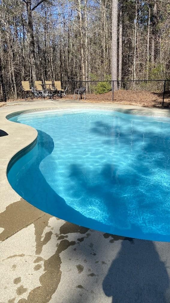 pool featuring fence and a patio area