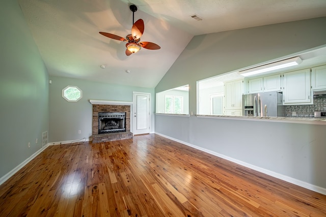 177 Wright Rd, Pine Mountain, GA 31822 - unfurnished living room with wood-type flooring, a ceiling fan, a brick fireplace, and high vaulted ceiling