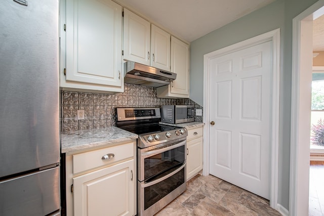 177 Wright Rd, Pine Mountain, GA 31822 - kitchen featuring stainless steel appliances, under cabinet range hood, backsplash, stone finish flooring, and white cabinetry