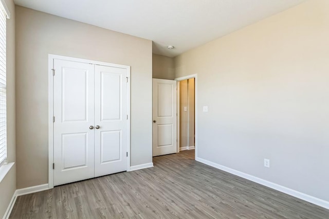 unfurnished bedroom featuring a closet and light hardwood / wood-style flooring