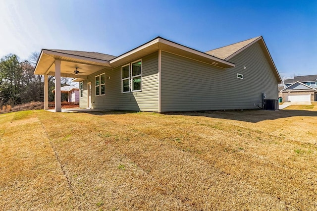 view of home's exterior with central AC, a yard, and ceiling fan