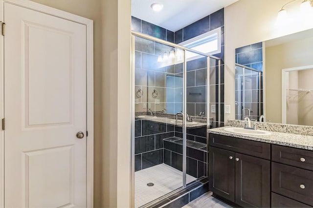 bathroom with vanity and a shower with door