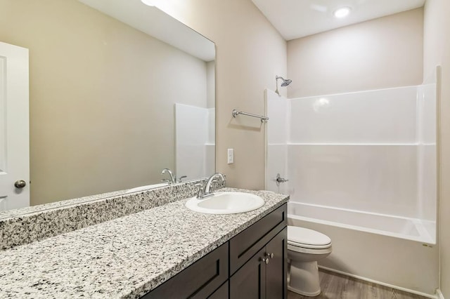 full bathroom featuring washtub / shower combination, toilet, vanity, and wood-type flooring