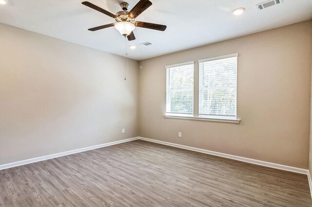 spare room featuring hardwood / wood-style floors and ceiling fan