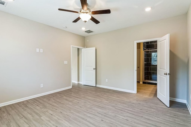 unfurnished bedroom featuring light hardwood / wood-style floors, a closet, a walk in closet, and ceiling fan