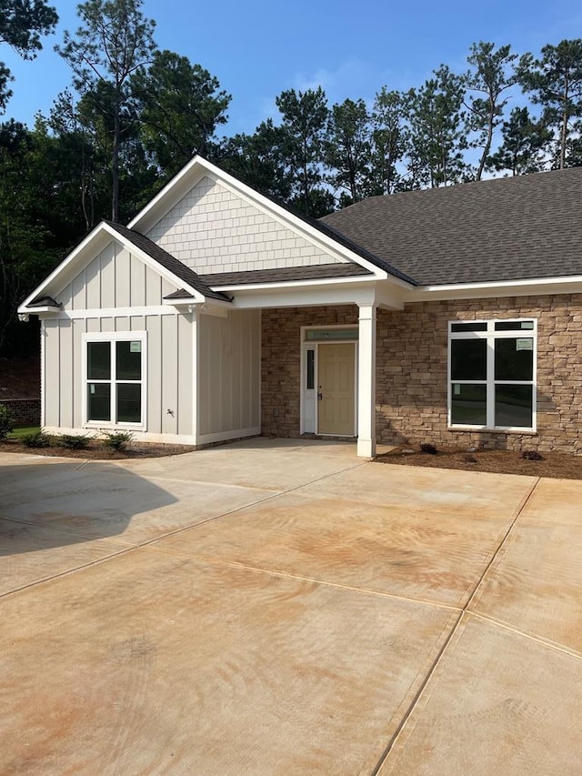 8033 Splendor Way, Columbus, GA 31904 - view of front of property featuring board and batten siding, roof with shingles, driveway, and stone siding
