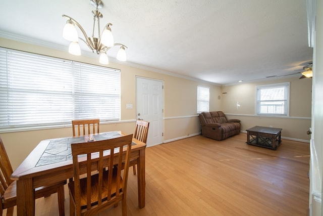 dining area featuring ornamental molding, a textured ceiling, a chandelier, and light hardwood / wood-style flooring