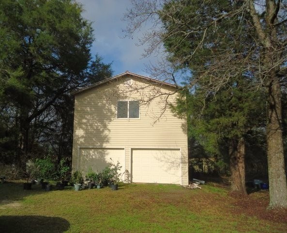 view of property exterior featuring a yard and driveway