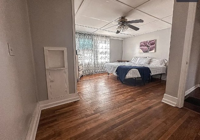 bedroom with ceiling fan, wood finished floors, and baseboards