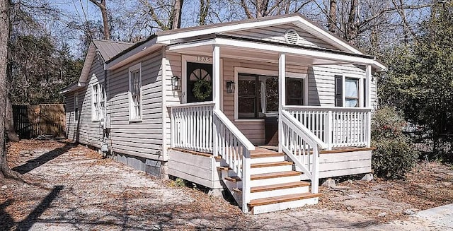 view of front of home with covered porch, metal roof, and crawl space