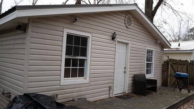 exterior space with metal roof, fence, and a wooden deck