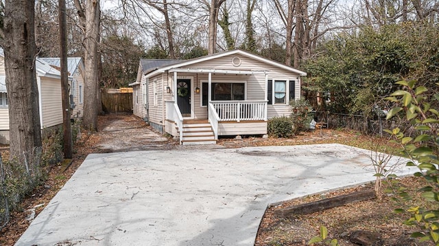 view of front facade featuring metal roof, fence, and a porch