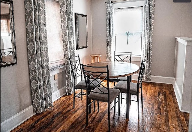 dining space with hardwood / wood-style flooring and baseboards