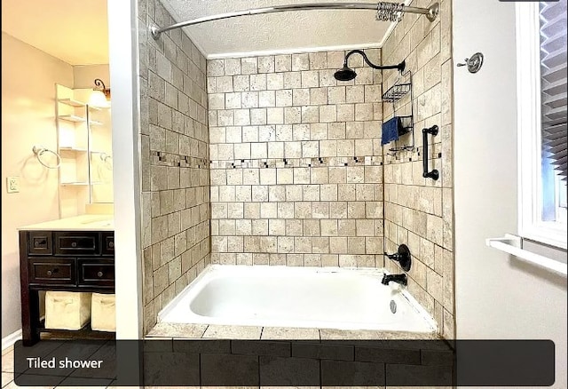 bathroom featuring tiled shower / bath combo and vanity