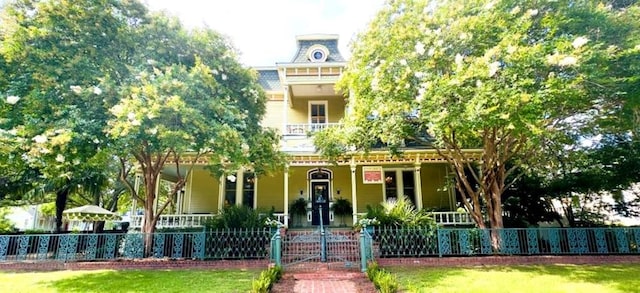 201 7th St, Columbus, GA 31901 - victorian-style house featuring covered porch, a fenced front yard, and a gate