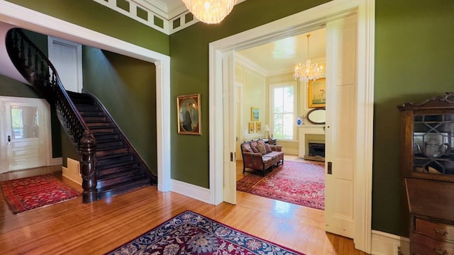 201 7th St, Columbus, GA 31901 - staircase featuring a chandelier, wood finished floors, crown molding, and a fireplace with flush hearth
