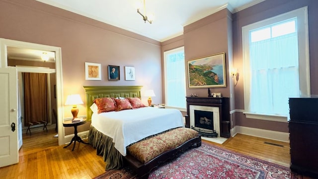 201 7th St, Columbus, GA 31901 - bedroom with crown molding, wood finished floors, and a fireplace with flush hearth