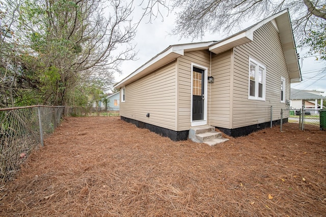 rear view of house with crawl space, entry steps, and a fenced backyard