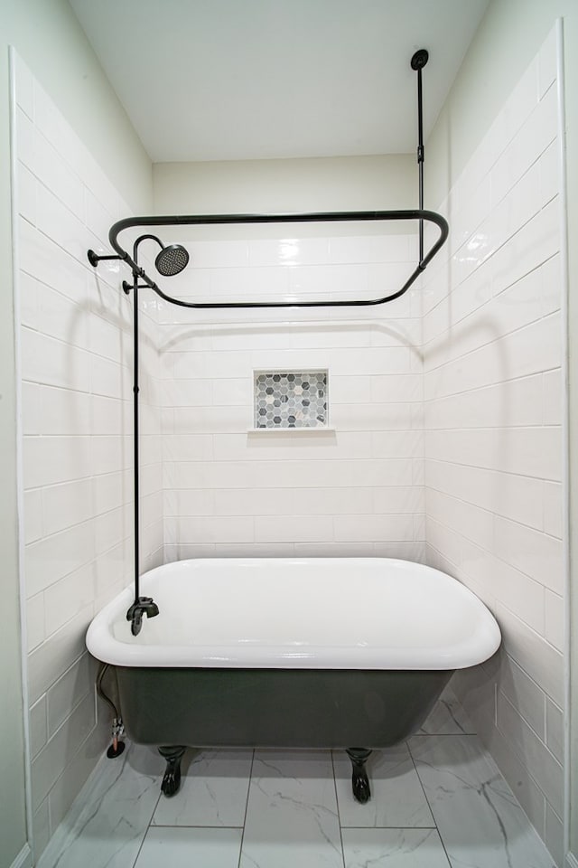 bathroom featuring a shower, a freestanding tub, tile walls, and marble finish floor