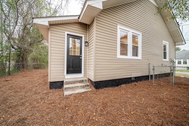 property entrance featuring crawl space and fence