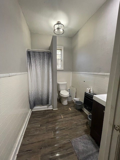 bathroom with toilet, vanity, a shower with shower curtain, and hardwood / wood-style flooring