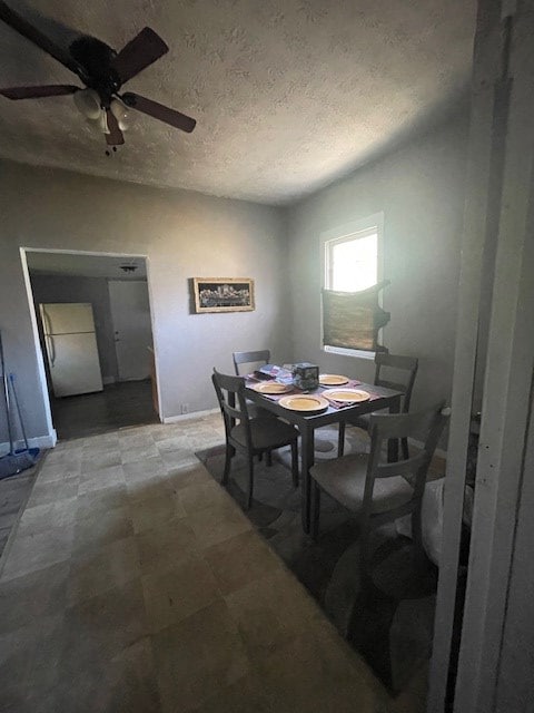 dining room featuring a textured ceiling and ceiling fan