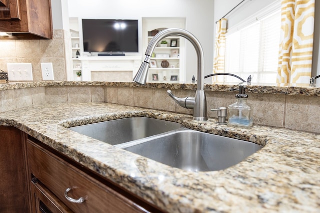 71 Greystone Ct, Smiths Station, AL 36877 - detailed view of a sink, light stone counters, and tasteful backsplash