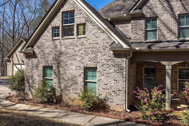 view of property exterior with brick siding and a garage