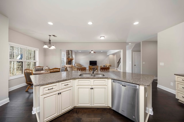 kitchen featuring baseboards, open floor plan, recessed lighting, stainless steel dishwasher, and a sink