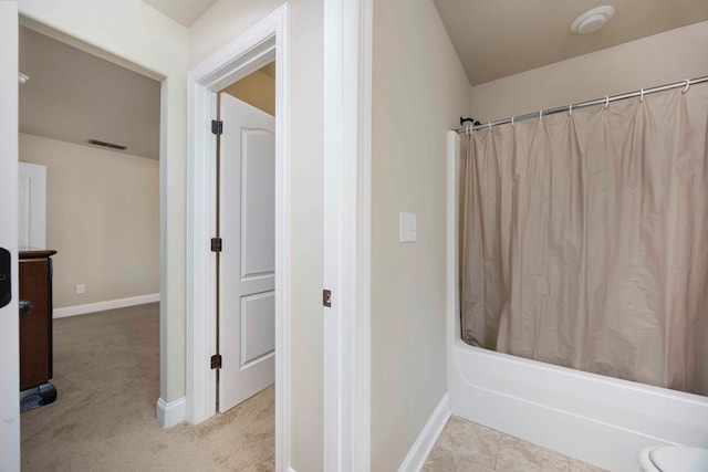 bathroom featuring visible vents, baseboards, and shower / bath combo