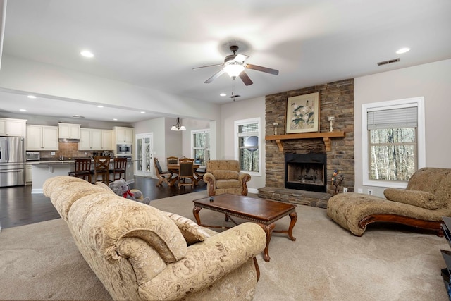 living area featuring dark wood-style floors, visible vents, a ceiling fan, a fireplace, and recessed lighting