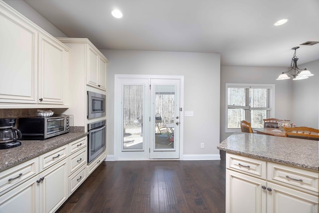 kitchen with visible vents, light stone countertops, a toaster, appliances with stainless steel finishes, and dark wood-style floors