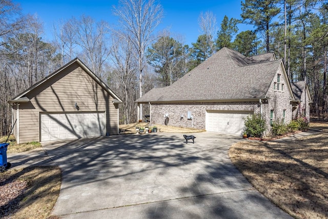 view of home's exterior featuring brick siding, a shingled roof, and a garage