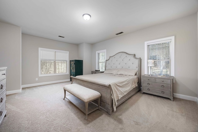 bedroom featuring baseboards, light carpet, and visible vents