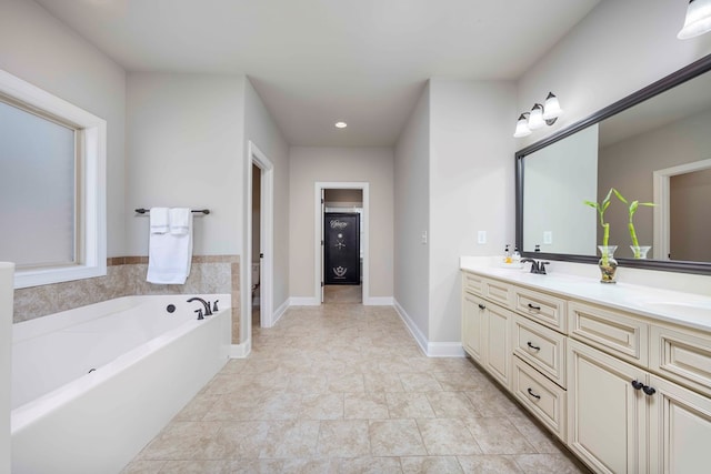 bathroom with a sink, baseboards, a garden tub, and double vanity