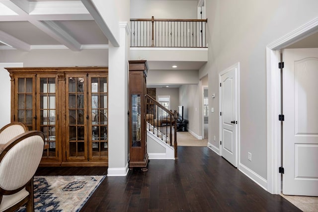 foyer with beam ceiling, hardwood / wood-style flooring, recessed lighting, stairway, and baseboards