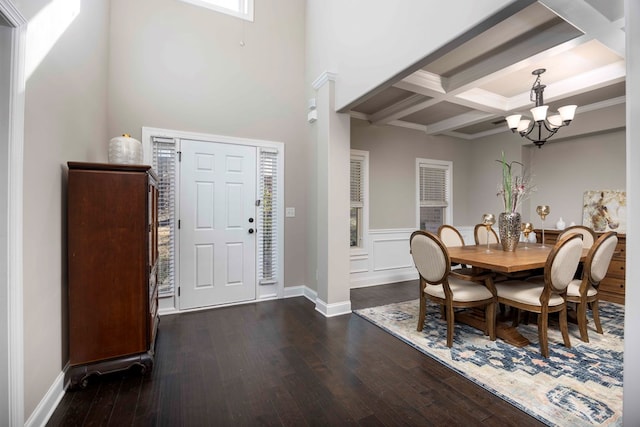 dining area featuring dark wood-style floors, beamed ceiling, coffered ceiling, and a chandelier