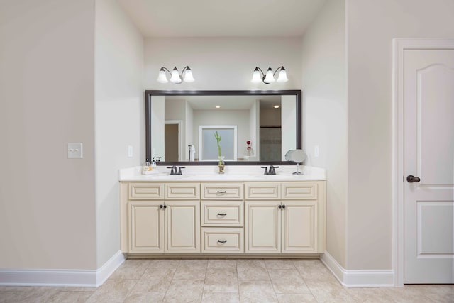 full bath featuring a sink, baseboards, double vanity, and tile patterned floors